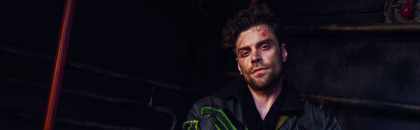 портрет небритого человека с травмированным лицом, смотрящего в камеру в темном постапокалиптическом метро, баннер