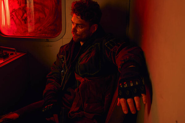 вдумчивый человек с пистолетом сидит в грязном вагоне метро с красным светом, выживание после катастрофы
