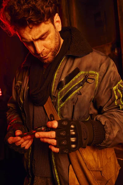 stock image thoughtful man in worn clothes holding pressure gauge in subway carriage, post-disaster survival