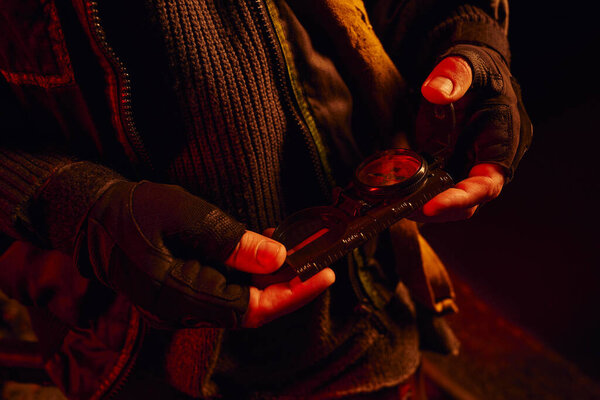 partial view of man in fingerless gloves with pressure gauge of carriage in abandoned subway