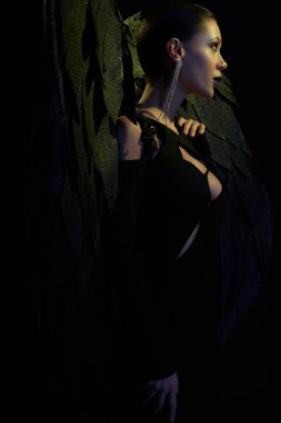 Şeytani cazibe, cadılar bayramı kostümlü, siyah kanatlı seksi kadın.