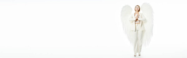 таинственная женщина в Хэллоуинском костюме божественного ангела с крыльями молится на белом фоне, знамя