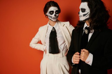 woman in skeleton makeup and white suit looking at spooky man on red, dia de lost muertos tradition clipart