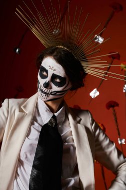 dia de los muertos catrina makyaj ve taç zarif kadın kırmızı çiçek arkaplan uzağa bakıyor