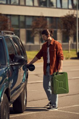 eye catching bearded man with accessories and ponytail in brown shirt refueling his car with patrol clipart