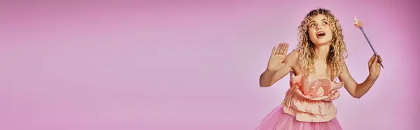 Mooie Krullende Vrouw Met Opgeheven Handen Toverstaf Poseren Roze Achtergrond — Stockfoto
