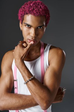 Pembe saçlı yakışıklı Afro-Amerikalı adam kameraya, modaya ve tarzına bakıyor.