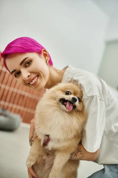 Zachwycony Pracownik Hotelu Zwierzak Obejmujący Puszyste Pomeranian Spitz Uśmiechając Się — Zdjęcie stockowe