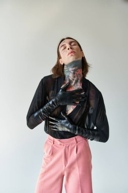 Güzel giyinmiş, deri eldivenli, gözleri kapalı yakışıklı bir adamın dikey çekimi.