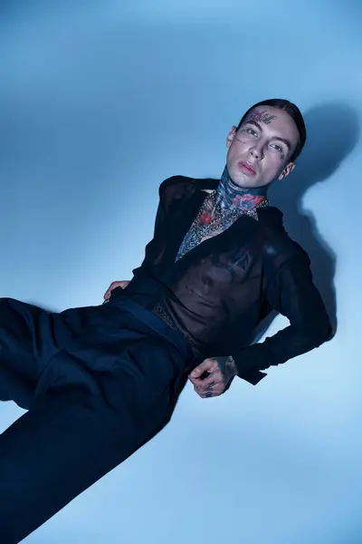 stock image sexy handsome man with stylish tattoos lying on floor and looking at camera, fashion concept