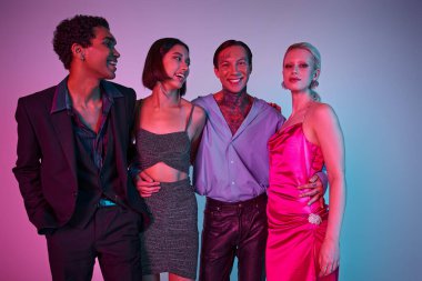 Şenlikli giyinmiş neşeli ırklar arası erkekler ve mor pembeyle Noel 'i kutlayan elbiseli kadınlar.