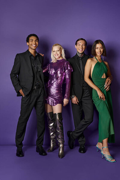 Christmas party, joyful multiethnic male and female friends in festive attire hugging on purple