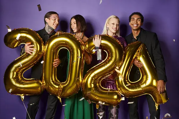 stock image New Year party, joyous interracial friends in suits and dresses holding balloons with numbers 2024