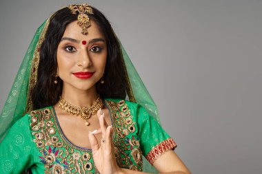 Alnında bindi noktasıyla güzel Hintli bir kadının portresi jest yapıyor ve kameraya bakıyor.