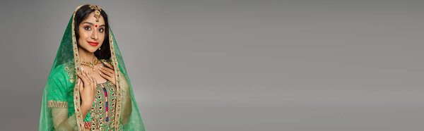 attractive indian woman with bindi dot in national costume and green veil looking at camera, banner