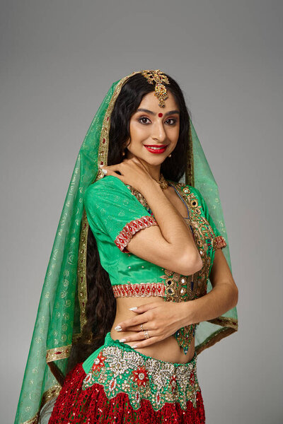 vertical shot of attractive indian woman with long hair and bindi dot smiling joyfully at camera