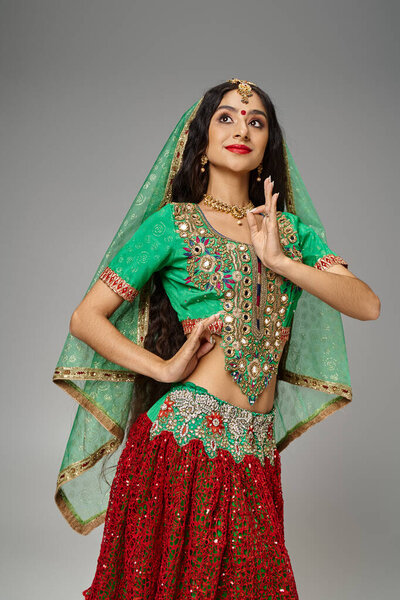 vertical shot of beautiful long haired indian woman with bindi dot gesturing and looking away
