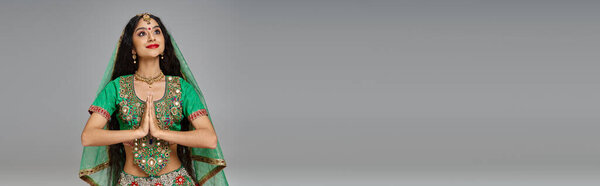 beautiful indian woman in national costume with accessories praying and looking away, banner