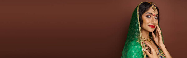 Веселая молодая индианка в национальной одежде с бинди точка улыбаясь и глядя на камеру, баннер