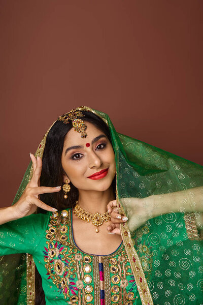 вертикальный снимок красивой молодой индианки, жестикулирующей во время танцев и смотрящей в камеру