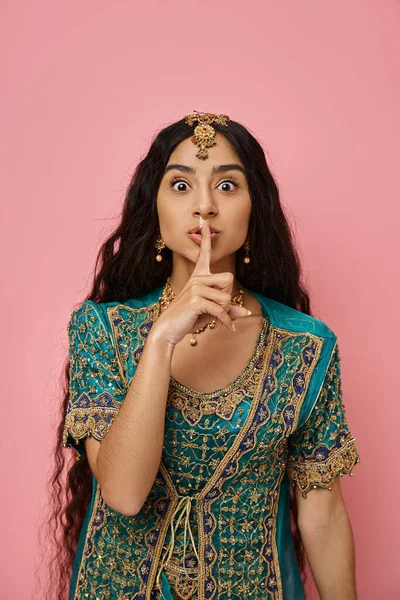stock image vertical shot of young pretty indian woman in blue sari showing silence gesture looking at camera