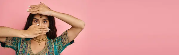 stock image beautiful indian woman in blue sari covering her face with hands while dancing lively, banner