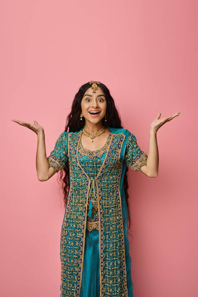 vertical shot of attractive indian woman in traditional clothing posing on pink background