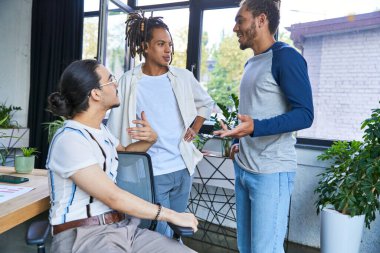 Modern ofiste çok ırklı erkekler yeni başlayan proje, modern iş konsepti üzerinde çalışırken konuşuyor