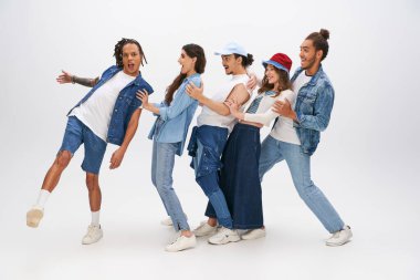 Heyecanlı Afro-Amerikan erkeği şık ırklar arası arkadaşlarının yanında dil uzatıyor ve grilerle eğleniyor.