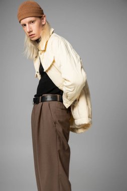 attractive young non binary person with long hair posing and looking at camera, fashion concept clipart