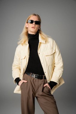 appealing androgynous model in stylish outfit with sunglasses posing with hands in pockets, fashion clipart