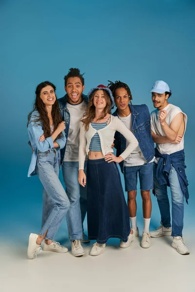 Moda kıyafetleri içinde, mavi kameraya bakan mutlu, çok kültürlü arkadaşlarla dolu.