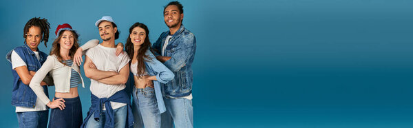 joyful multicultural friends in trendy street wear looking at camera on blue, horizontal banner