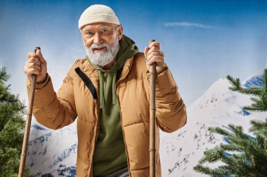 Kayakların üzerinde duran neşeli adam beyaz şapkalı ve ceketli dağ manzaralı, kış konsepti