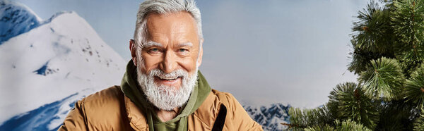 joyful Santa with white beard smiling at camera with mountains backdrop, winter concept, banner