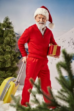 Noel şapkalı neşeli Noel Baba bavullu ve hediyeli, kış konsepti