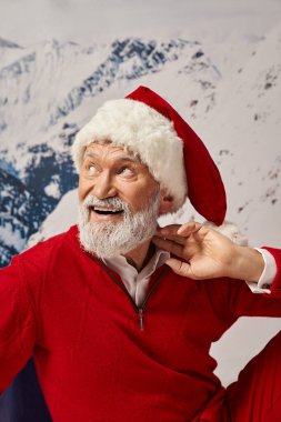 Noel Baba kostümü giymiş neşeli bir adamın portresi. Boynuna yakın, başka yere bakıyor. Kış konsepti.