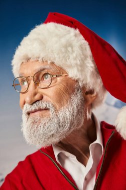 Noel Baba kostümlü beyaz sakallı yaşlı adam gözlük takıyor ve uzaklara bakıyor, kış konsepti.