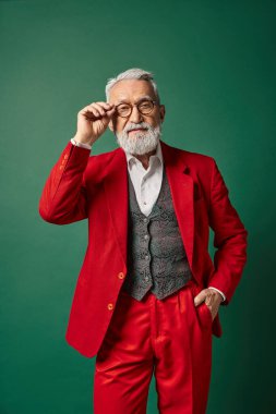 elegant classy Santa with white beard and glasses posing with one hand in pocket, winter concept clipart