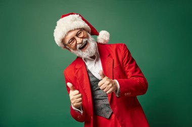 Mutlu Noel Baba 'nın başparmak hareketi ve kameraya neşeli bir şekilde gülümsemesi, Noel konsepti