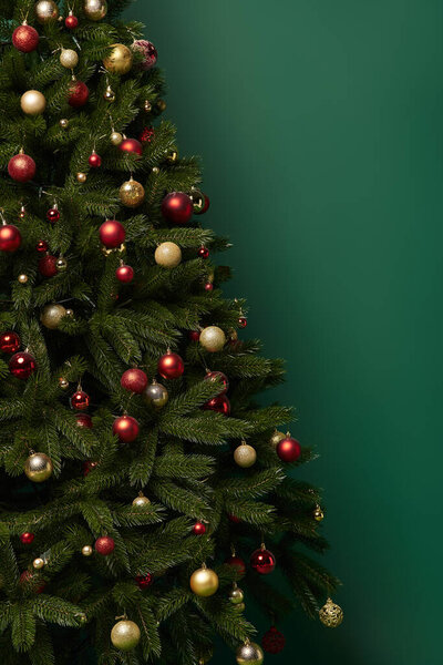 украшенная елка с красивыми безделушками на темно-зеленом фоне, зимняя концепция
