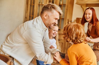 carefree parents and children having fun and playing in cozy kitchen at home, bonding moments clipart