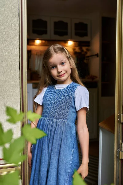 stock image smiling girl with long blonde hair in stylish denim dress smiling at camera from trailer home