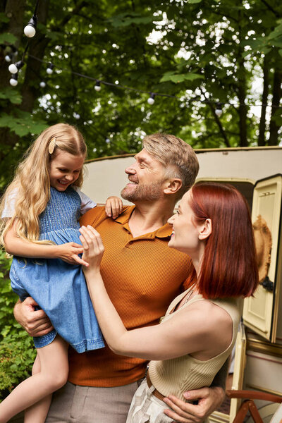 отец держа смеясь дочь рядом довольная жена и мобильный дом в трейлерном парке, сближаясь