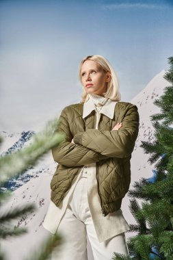 ciddi stil sahibi bir kadın kollarını göğsüne çarpmış ve uzaklara bakıyor, kış modası.
