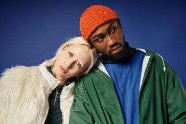 multiethnic couple posing in winter attire with mountain on backdrop, african american man and woman clipart