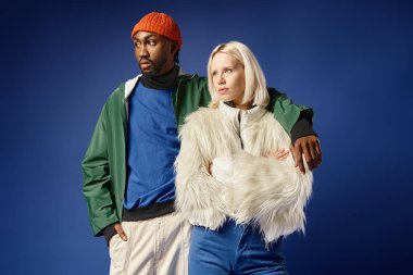 multiethnic couple posing in winter attire with mountain on backdrop, african american man and woman clipart