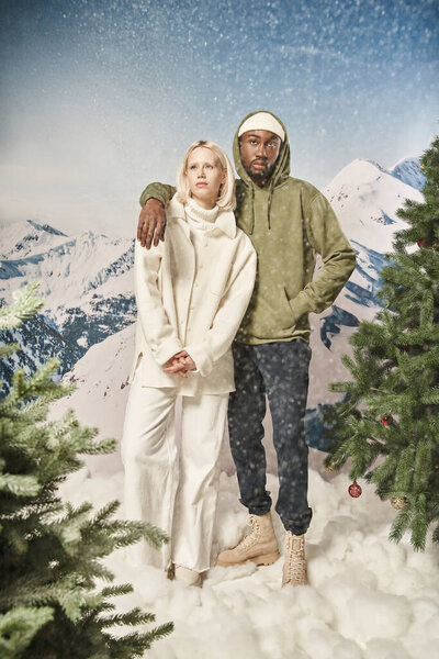 привлекательная пара позирует под снегопадом и носит стильную зимнюю одежду, моду и стиль