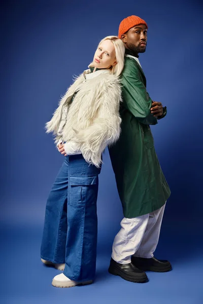 stock image multiethnic couple posing in winter attire with mountain on backdrop, african american man and woman