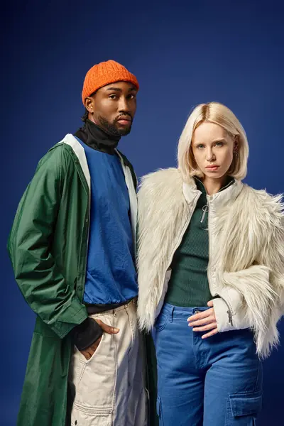 Kışın arka planda dağla poz veren çok ırklı çift, Afro-Amerikan erkek ve kadın.